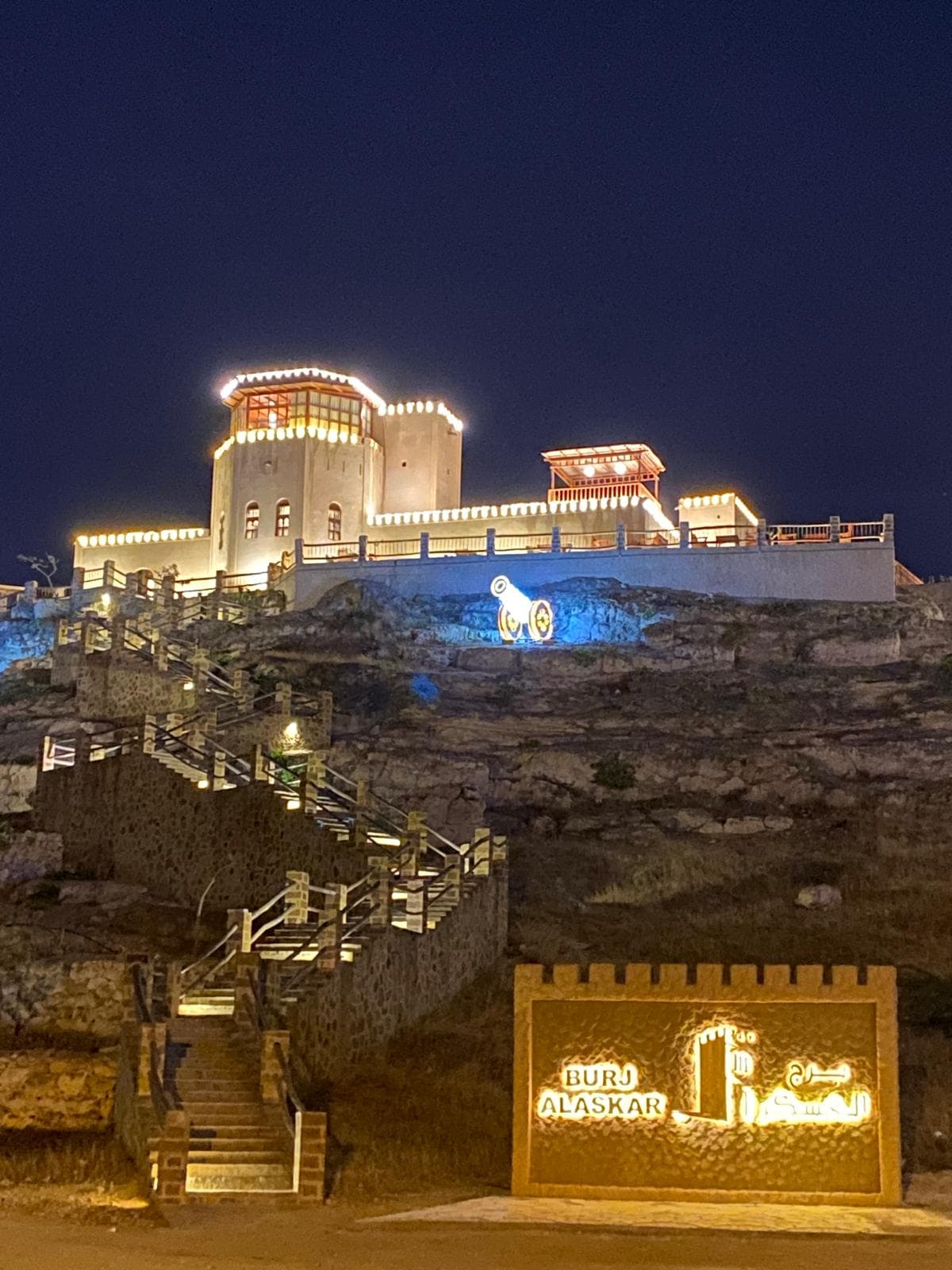 Osvětlená pevnost Burj Al Askar nad pobřežím po setmění